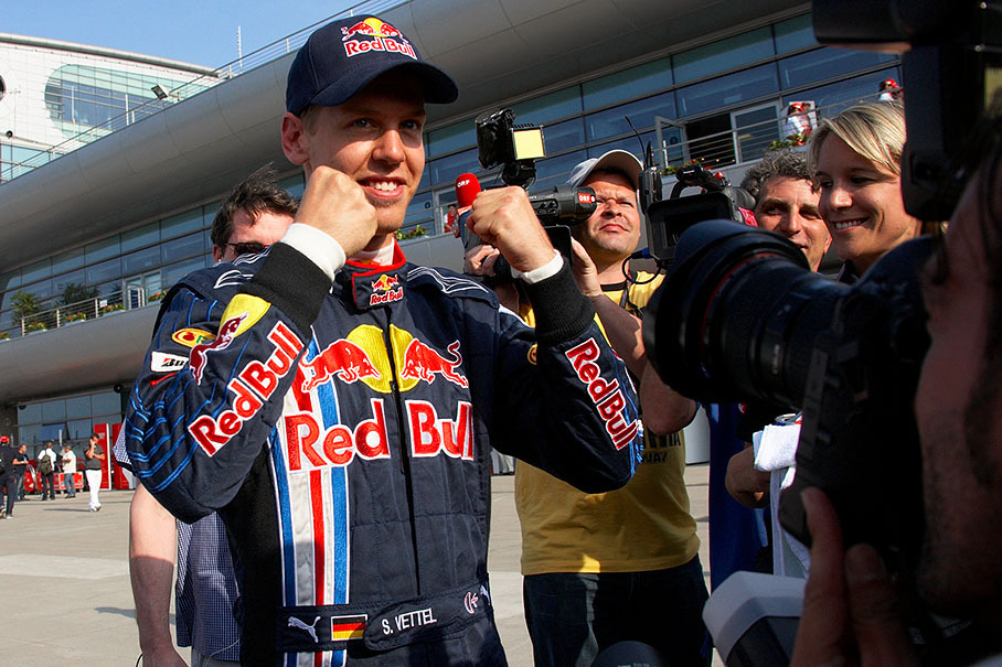 Polesetter Sebastian Vettel celebrates his achivement after qualifying in front of the greedy media