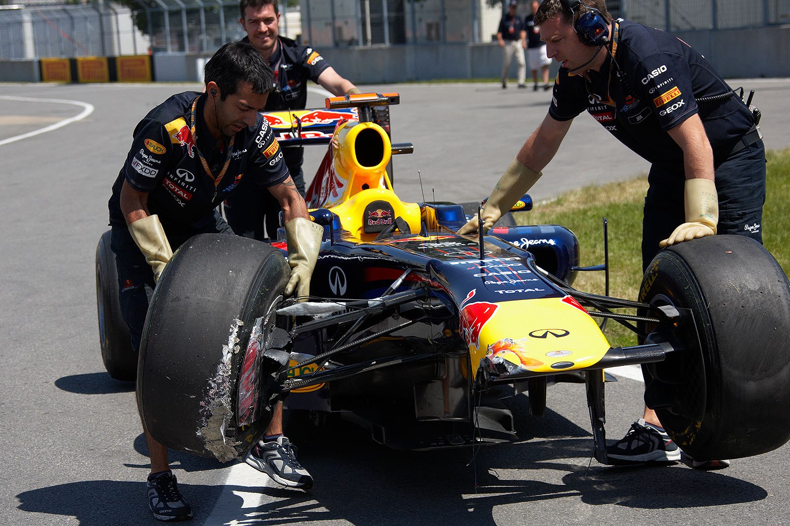 Sebastian Vettel's damaged Red Bull-Renault is collected by the mechanics on Friday morning