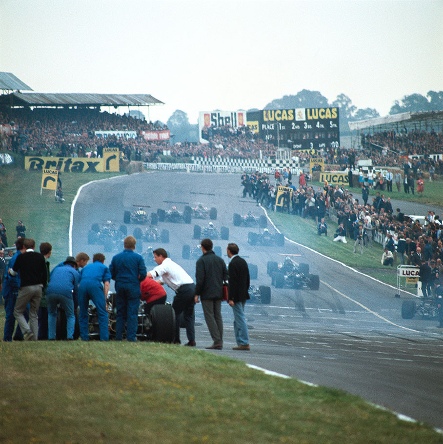 As Jack Brabham, 8th on the grid, in the foreground retires with a blown up engine, Jackie Oliver's Lotus takes the lead at the start