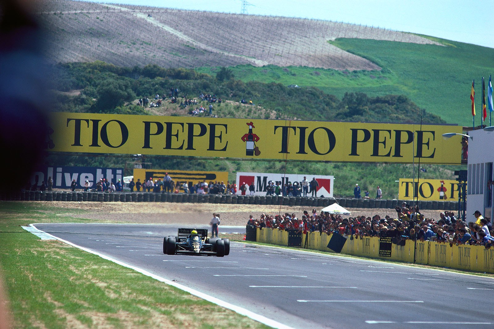 Race leader Ayrton Senna, Lotus-Renault, accelerates onto the start-finish straight and Mansell jinkes out trying to power past the Lotus