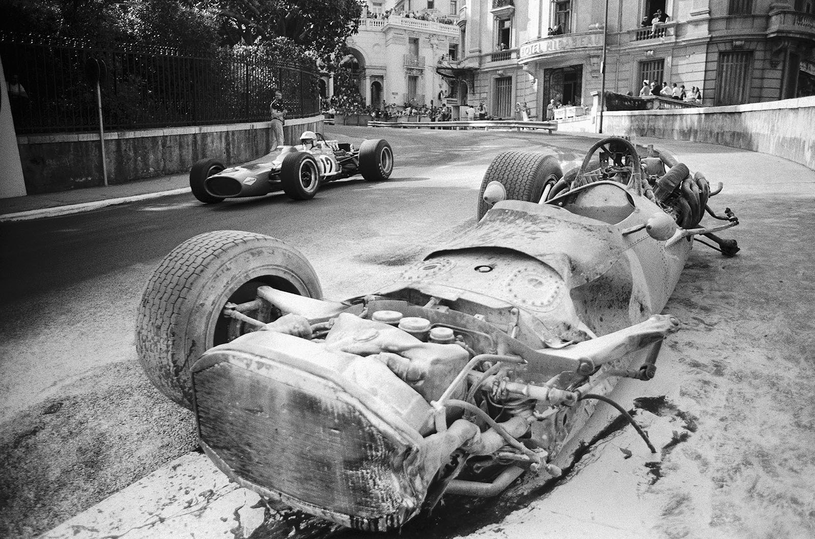 Denny Hulme on McLaren-Cosworth M7A passes Pedro Rodriguez' destroyed BRM P133, GP Monaco 1968