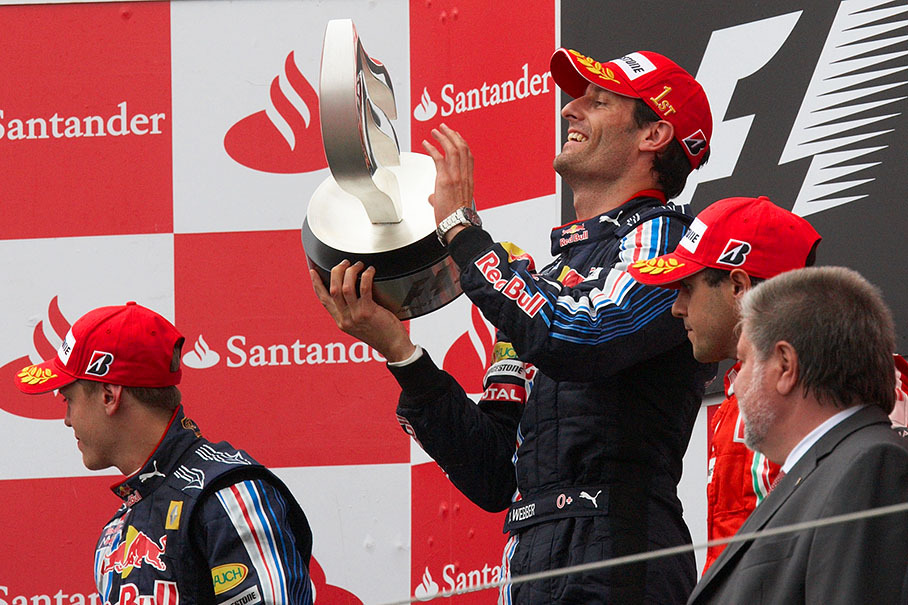 Race winner Mark Webber on podium raises his place trophy for his first first place